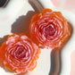 Two red rose-shaped candies on a white plate with a blurred background